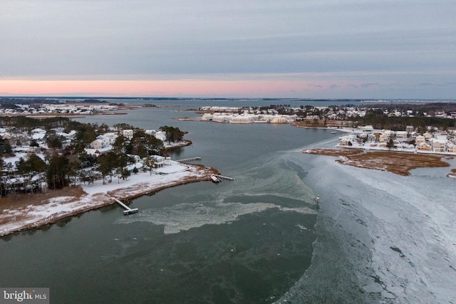 aerial view at dusk featuring a water view