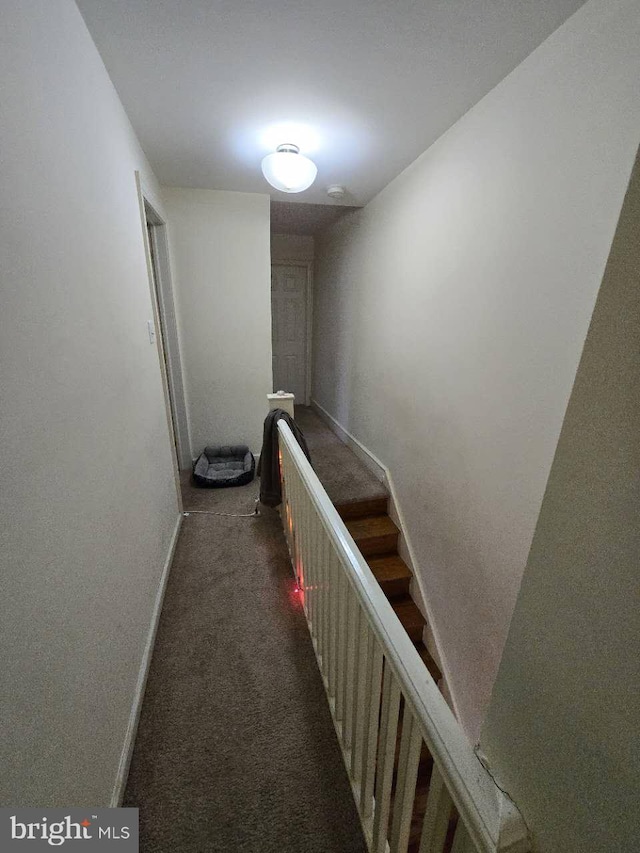 hallway featuring dark colored carpet