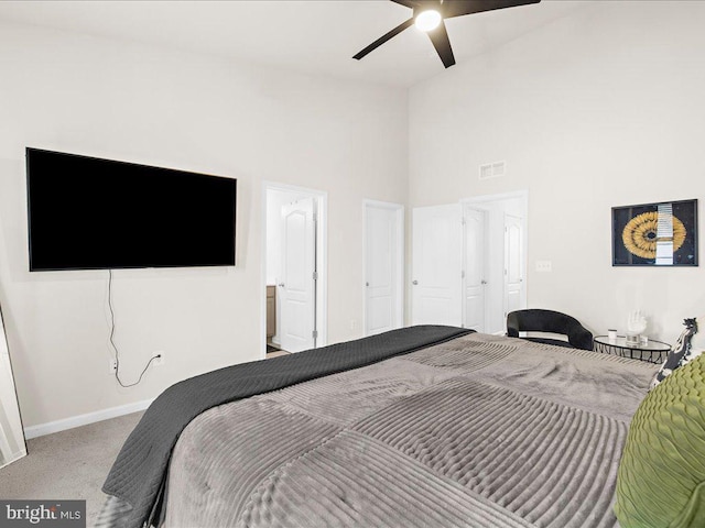 carpeted bedroom with a high ceiling and ceiling fan