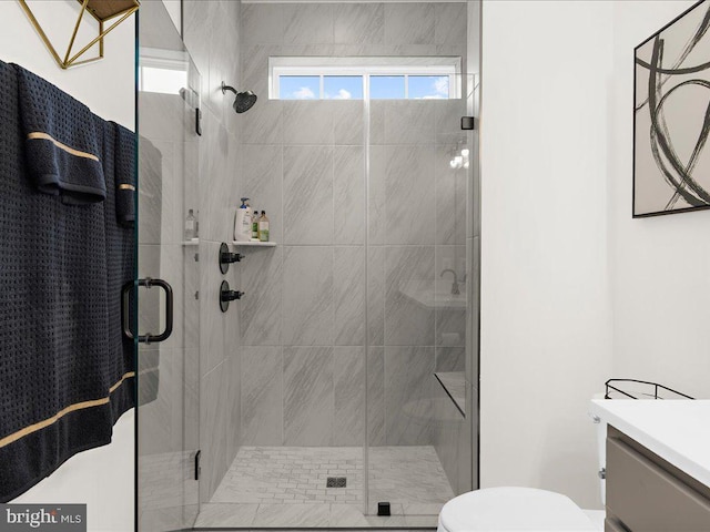 bathroom with vanity, a shower with shower door, and toilet