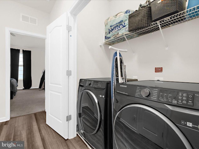 washroom with dark hardwood / wood-style flooring and washing machine and dryer