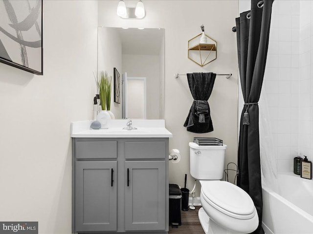 full bathroom featuring hardwood / wood-style floors, vanity, toilet, and shower / bathtub combination with curtain