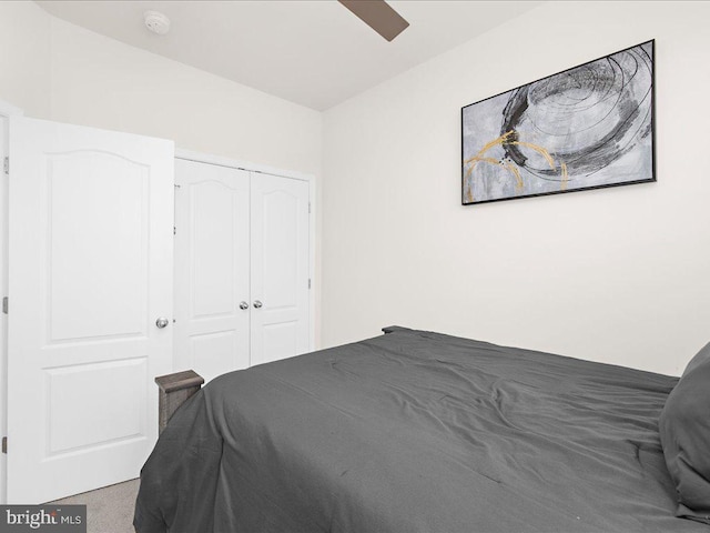 carpeted bedroom with ceiling fan and a closet