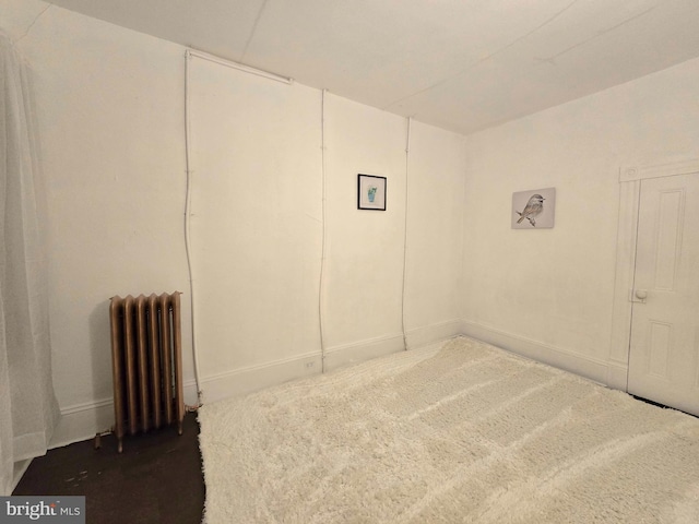 unfurnished bedroom featuring radiator heating unit