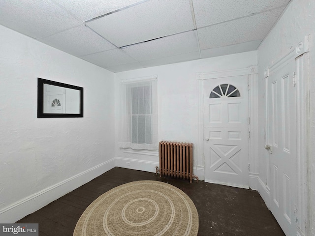 entrance foyer with radiator heating unit, a paneled ceiling, and dark hardwood / wood-style floors