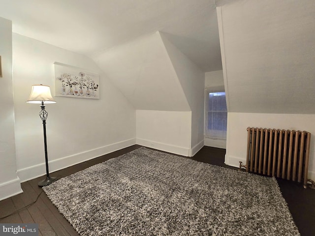 bonus room featuring dark hardwood / wood-style flooring, radiator, and lofted ceiling