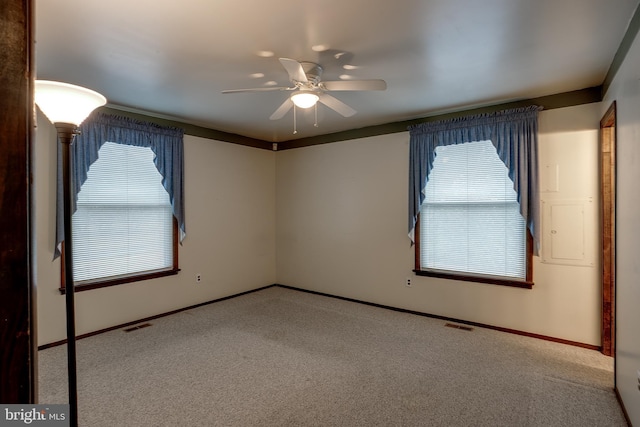 spare room with carpet, visible vents, ceiling fan, and baseboards