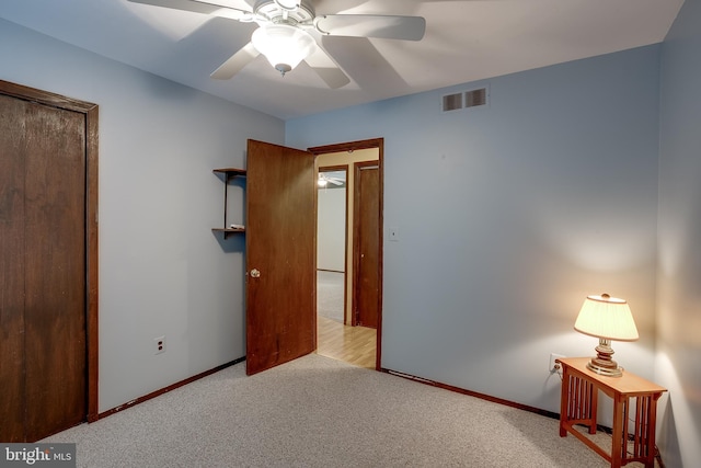 unfurnished bedroom featuring a ceiling fan, carpet, visible vents, and baseboards