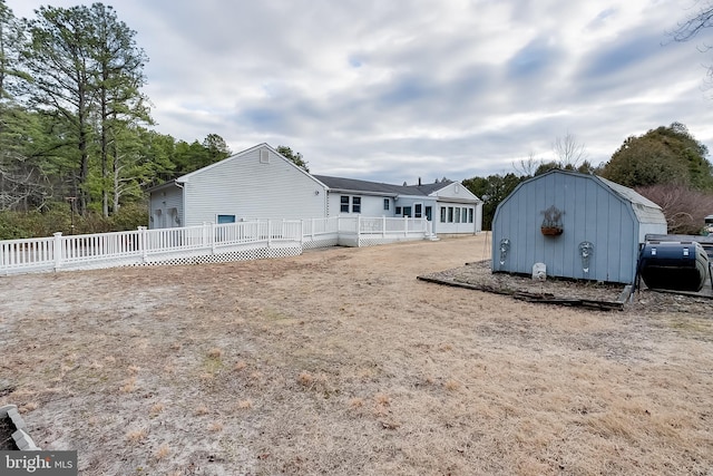 exterior space with an outdoor structure, a storage shed, and fence