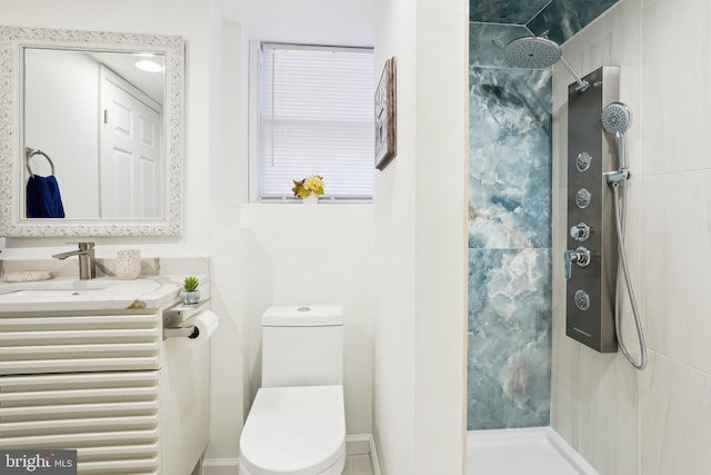 bathroom with vanity, tiled shower, and toilet