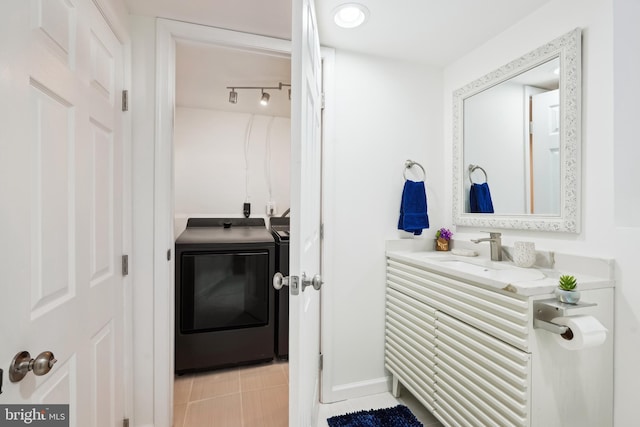 bathroom featuring tile patterned flooring, vanity, and independent washer and dryer