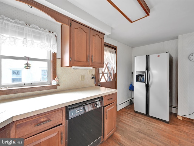 kitchen featuring a baseboard heating unit, decorative light fixtures, light hardwood / wood-style flooring, dishwasher, and white fridge with ice dispenser