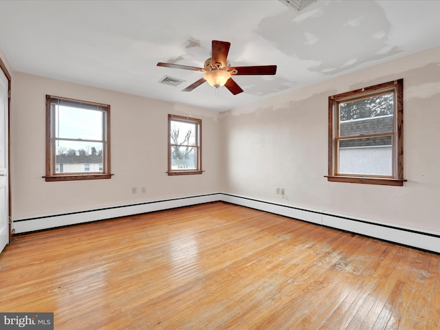 empty room featuring light hardwood / wood-style floors, a wealth of natural light, and ceiling fan