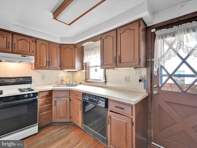 kitchen with dishwasher, sink, light hardwood / wood-style flooring, decorative backsplash, and white gas range