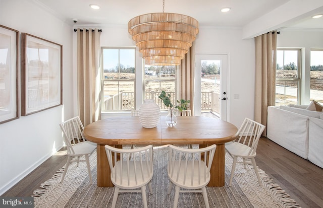 dining room with ornamental molding, dark hardwood / wood-style floors, and a notable chandelier