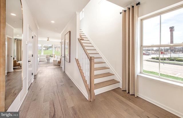 stairway featuring hardwood / wood-style floors and ornamental molding