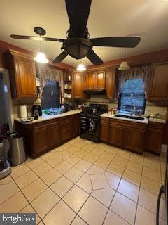 kitchen featuring stove, light tile patterned floors, ceiling fan, and pendant lighting