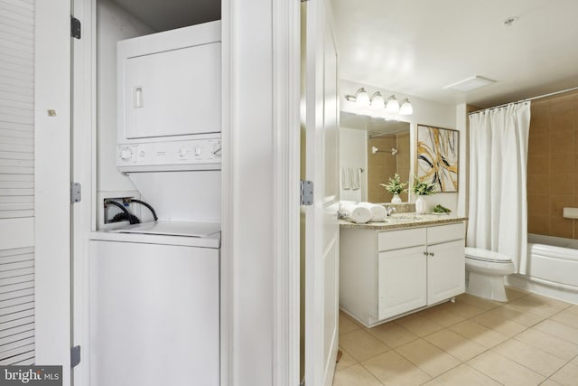 interior space with sink, light tile patterned floors, and stacked washing maching and dryer