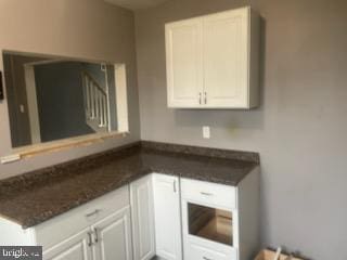 kitchen featuring white cabinets and dark stone counters