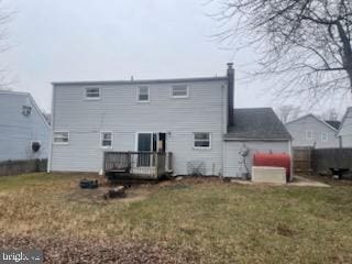 rear view of property featuring a yard and a wooden deck