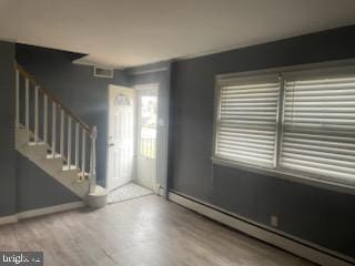 entrance foyer with hardwood / wood-style floors and a baseboard radiator