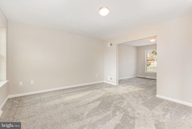 spare room featuring light colored carpet