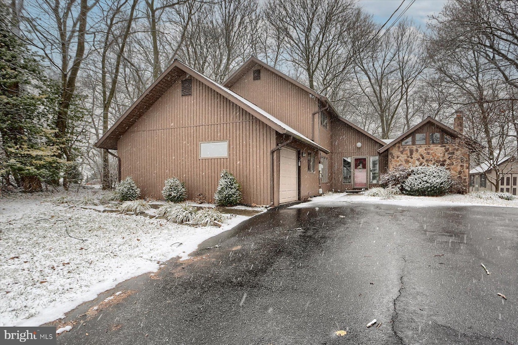 view of snow covered exterior with a garage