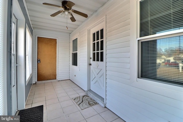 unfurnished sunroom featuring ceiling fan