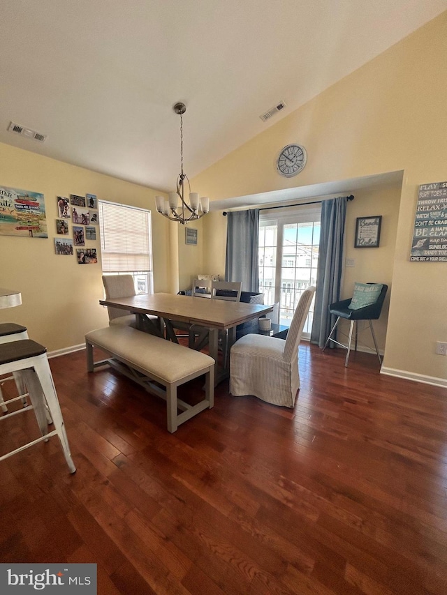 dining area with dark hardwood / wood-style floors, an inviting chandelier, and lofted ceiling