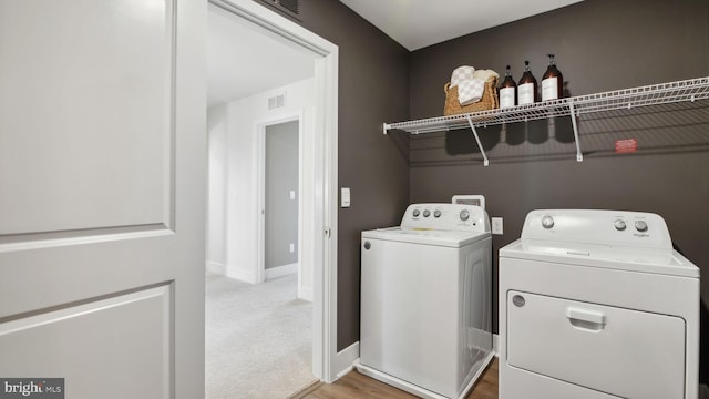 clothes washing area with carpet flooring and washer and clothes dryer