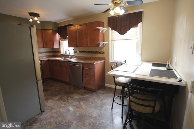 kitchen featuring tasteful backsplash, ceiling fan, sink, and stainless steel appliances