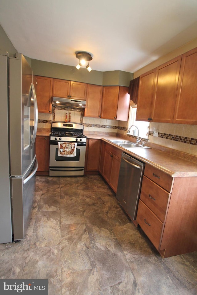 kitchen with backsplash, sink, and appliances with stainless steel finishes