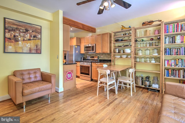 kitchen featuring tasteful backsplash, light hardwood / wood-style flooring, stainless steel appliances, and beam ceiling