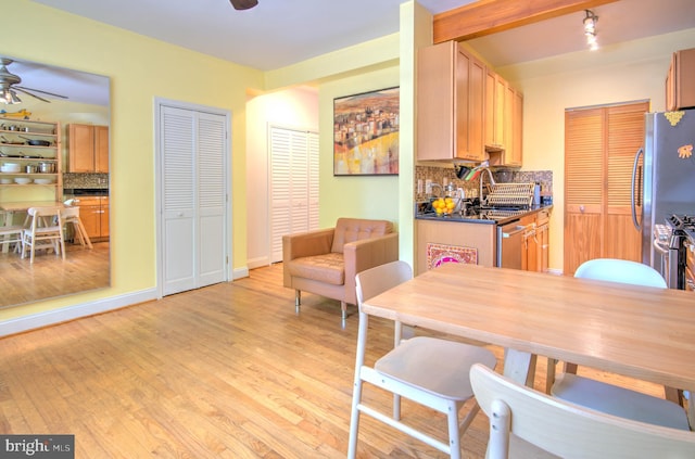 dining area featuring light hardwood / wood-style floors, ceiling fan, and sink