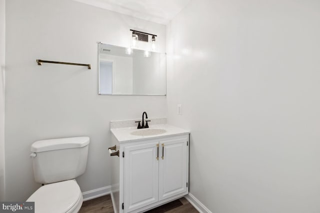 bathroom with hardwood / wood-style floors, vanity, and toilet