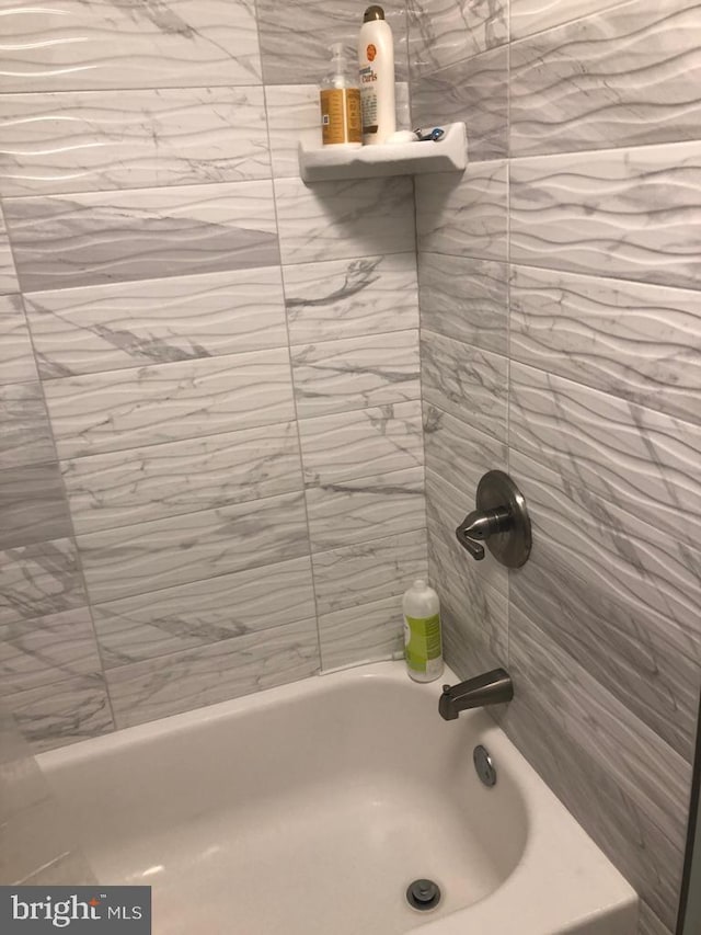 bathroom featuring tiled shower / bath