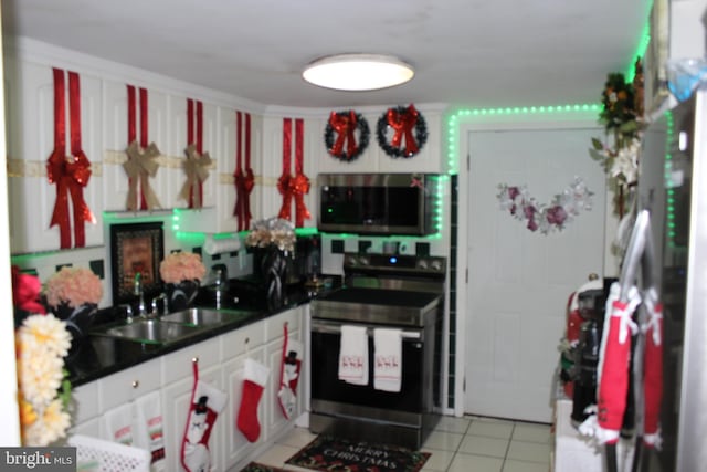 kitchen featuring light tile patterned flooring, sink, white cabinets, and stainless steel appliances