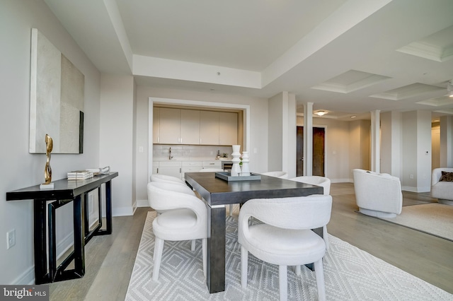 dining room featuring ornate columns and light hardwood / wood-style floors