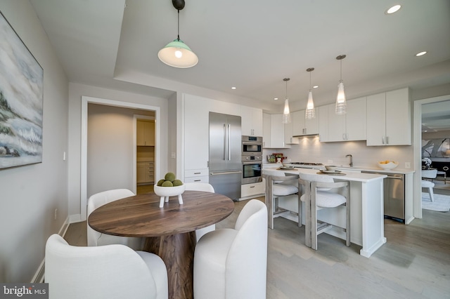 dining space featuring sink and light wood-type flooring