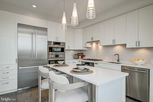 kitchen featuring white cabinetry, appliances with stainless steel finishes, sink, and pendant lighting