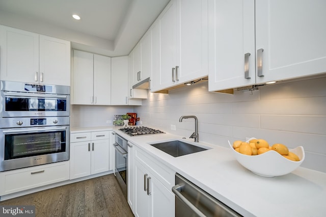 kitchen featuring dark hardwood / wood-style flooring, sink, stainless steel appliances, and white cabinets