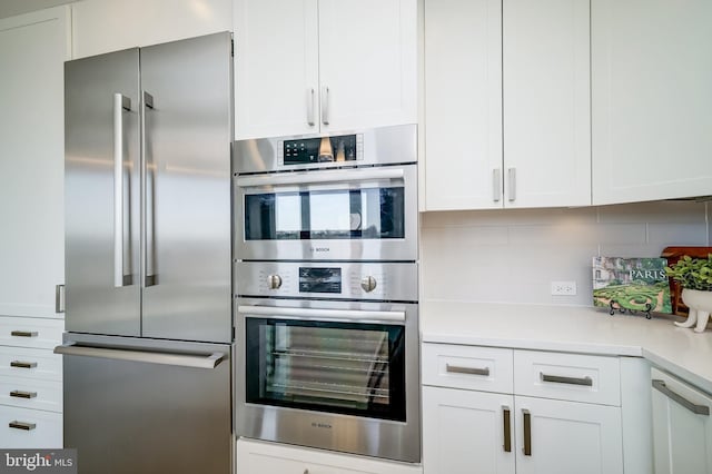 kitchen featuring white cabinetry, appliances with stainless steel finishes, and backsplash