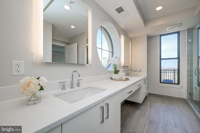 bathroom featuring vanity and an enclosed shower