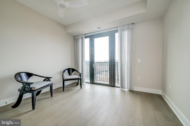 living area with ceiling fan and light wood-type flooring