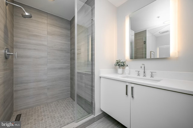 bathroom with a shower with door and vanity