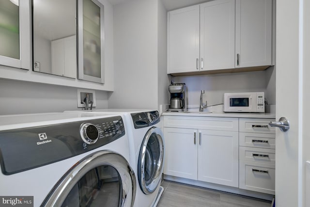 washroom featuring cabinets and separate washer and dryer