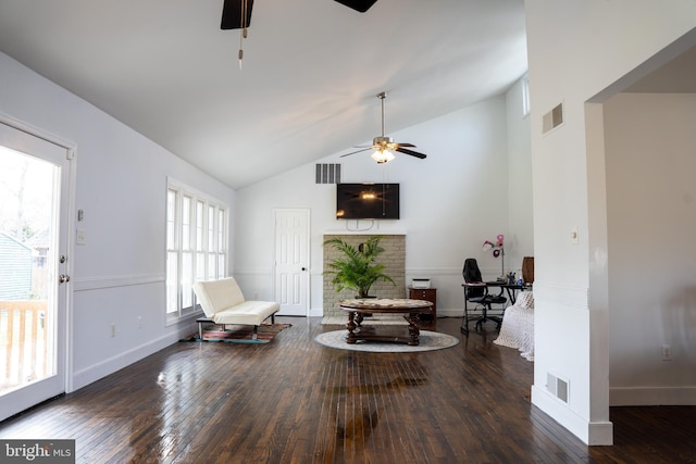 living area featuring ceiling fan, vaulted ceiling, and dark wood-type flooring