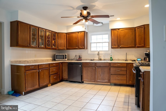 kitchen with light tile patterned floors, backsplash, sink, and stainless steel appliances