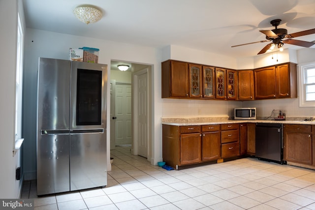 kitchen featuring light tile patterned floors, ceiling fan, appliances with stainless steel finishes, and backsplash