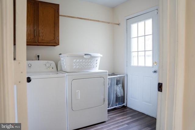 clothes washing area with dark wood-type flooring, cabinets, and washer and clothes dryer